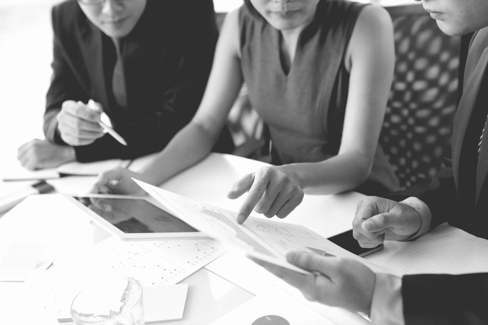 Teilnehmer beim gemeinsamen Lernen mit Finanzunterlagen und Laptop